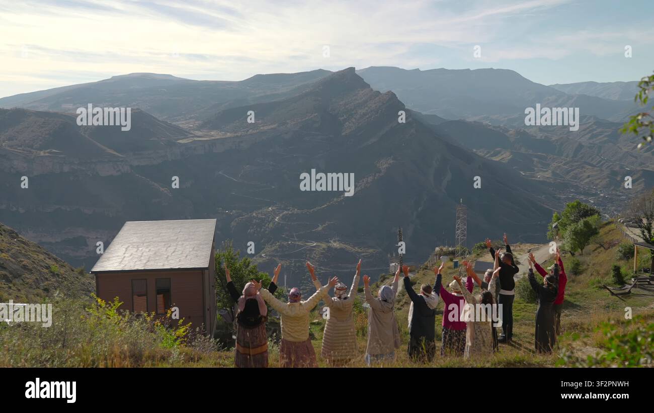Gli anziani guidano un rituale di benedizione tradizionale. Evento comunitario pacifico in un paesaggio montano sereno. Creativo Foto Stock