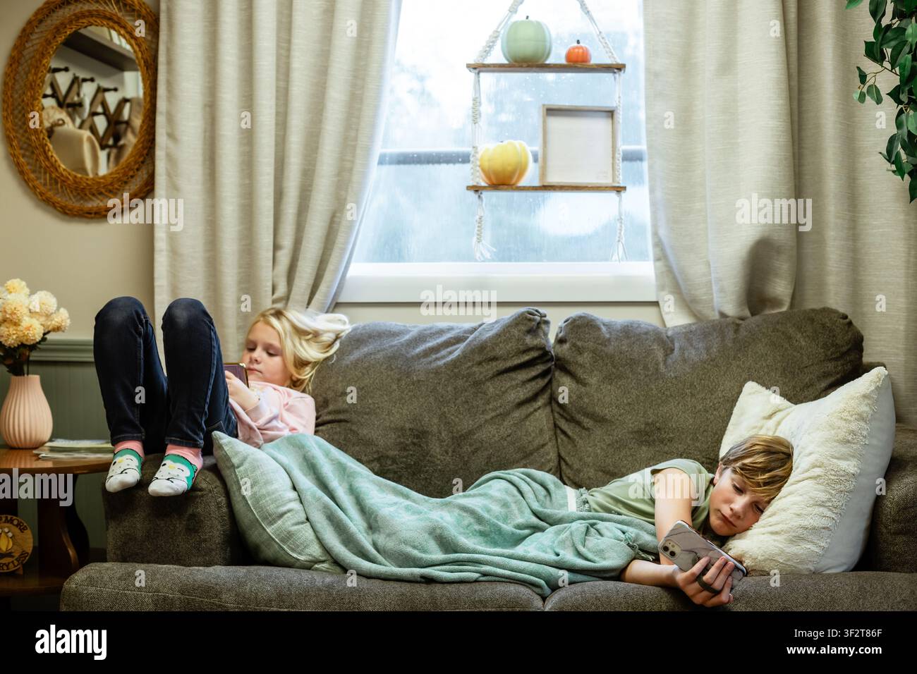 Fratelli e sorelle che passano il tempo davanti allo schermo insieme a casa Foto Stock
