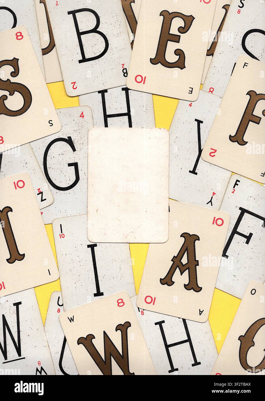Un montaggio di carte da gioco alfabetiche vintage su uno sfondo giallo brillante con spazio per testo o copia. Foto Stock