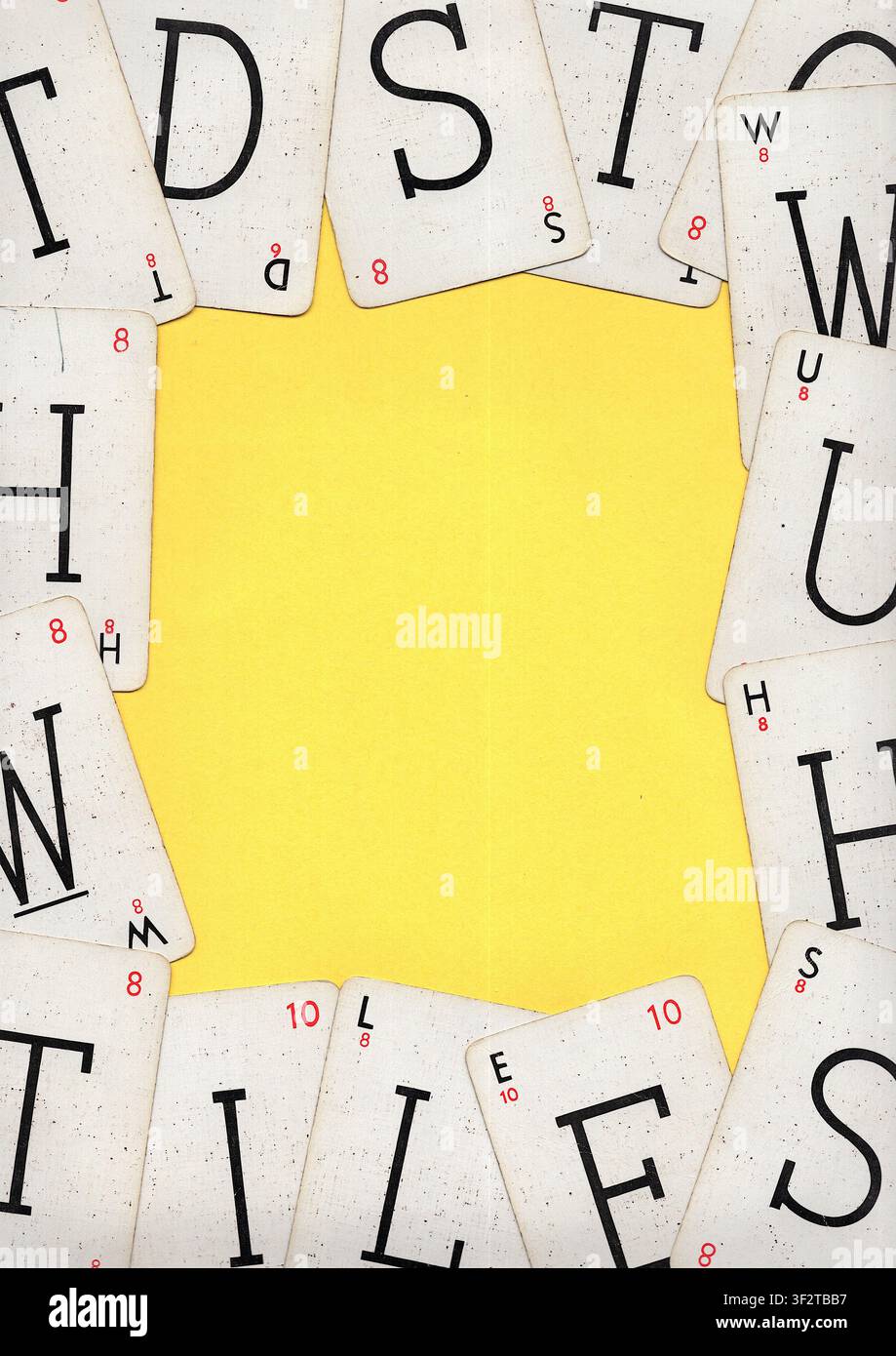 Un montaggio di carte da gioco alfabetiche vintage su uno sfondo giallo brillante con spazio per testo o copia. Foto Stock