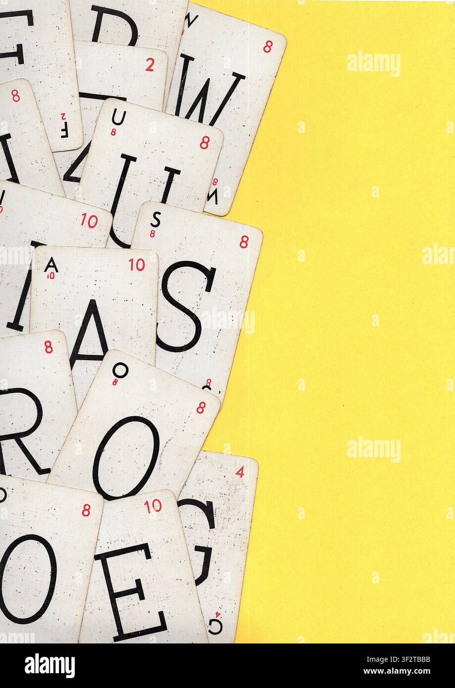 Un montaggio di carte da gioco alfabetiche vintage su uno sfondo giallo brillante con spazio per testo o copia. Foto Stock