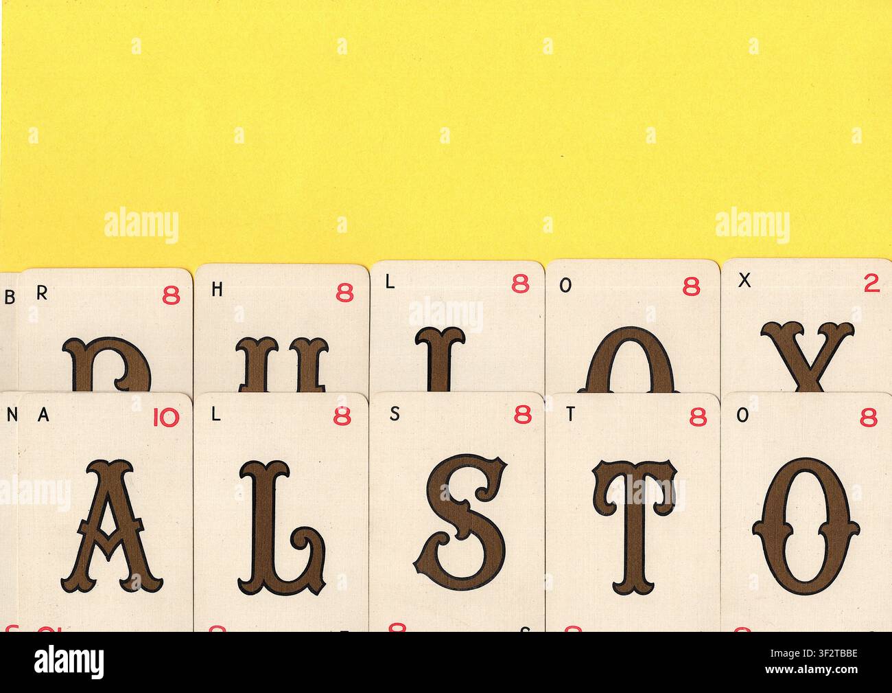 Un montaggio di carte da gioco alfabetiche vintage su uno sfondo giallo brillante con spazio per testo o copia. Foto Stock