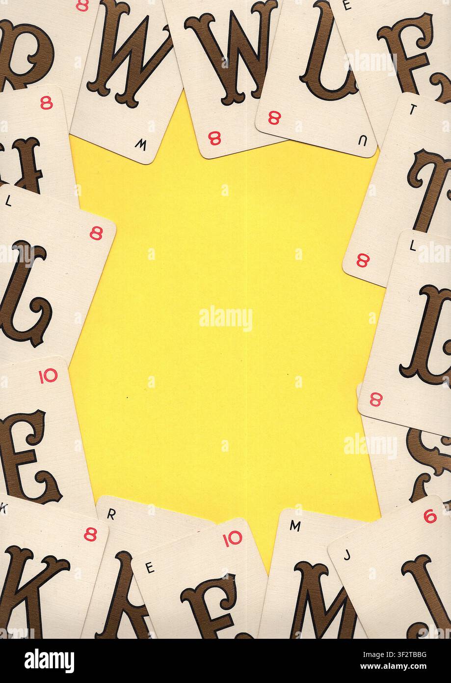 Un montaggio di carte da gioco alfabetiche vintage su uno sfondo giallo brillante con spazio per testo o copia. Foto Stock