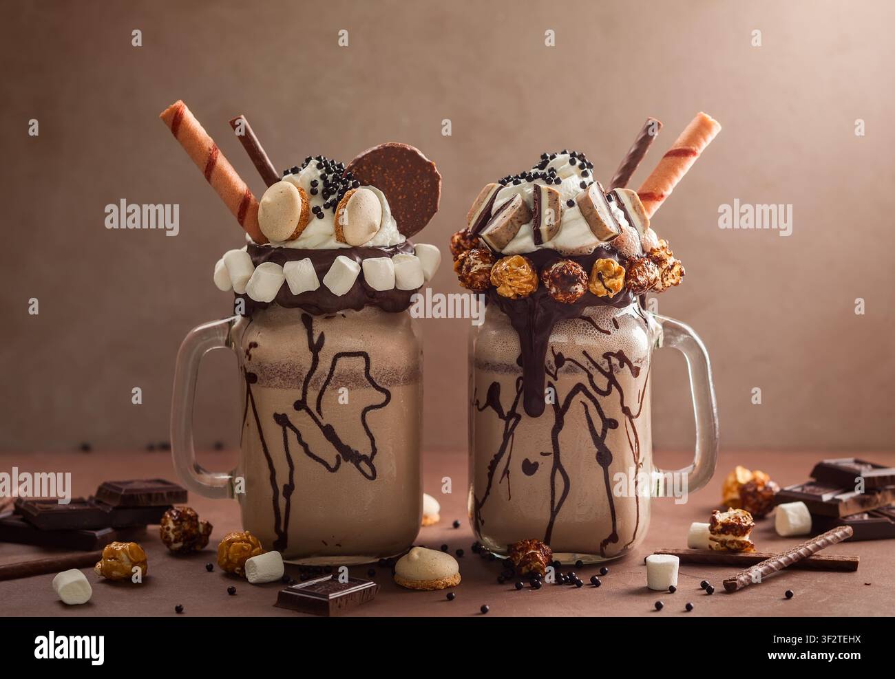 Frullato al cioccolato con gelato e panna montata, marshmallow, popcorn dolce, biscotti, waffle, servito in un barattolo di vetro mason. Foto Stock
