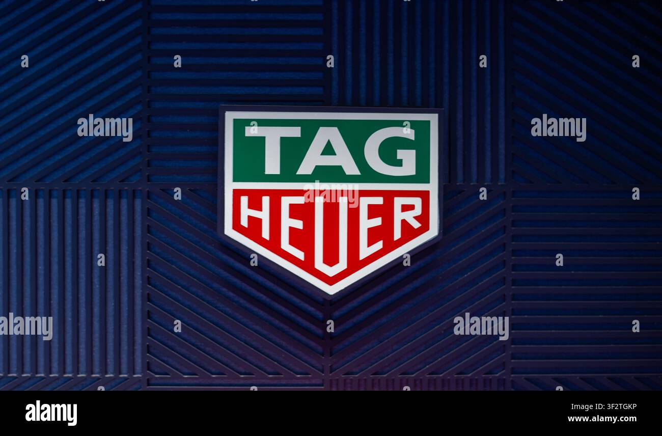 Logo TAG Heuer su uno sfondo blu texture Modelli Negozio del marchio. Como, Italia - 24 giugno 2026 Foto Stock