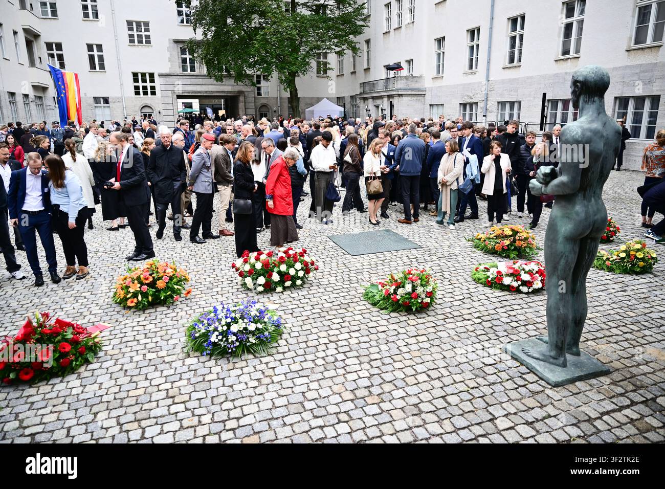 Berlino, Germania. 20 luglio 2026. Dopo una cerimonia commemorativa organizzata dal governo federale nel cortile del Bendlerblock per celebrare il Giorno nazionale della memoria della Resistenza contro la tirannia nazista, i partecipanti si trovano dietro le corone. Il giorno commemora il tentativo di assassinio fallito di Adolf Hitler il 20 luglio 1944. Credit: Sebastian Christoph Gollnow/dpa/Alamy Live News Foto Stock