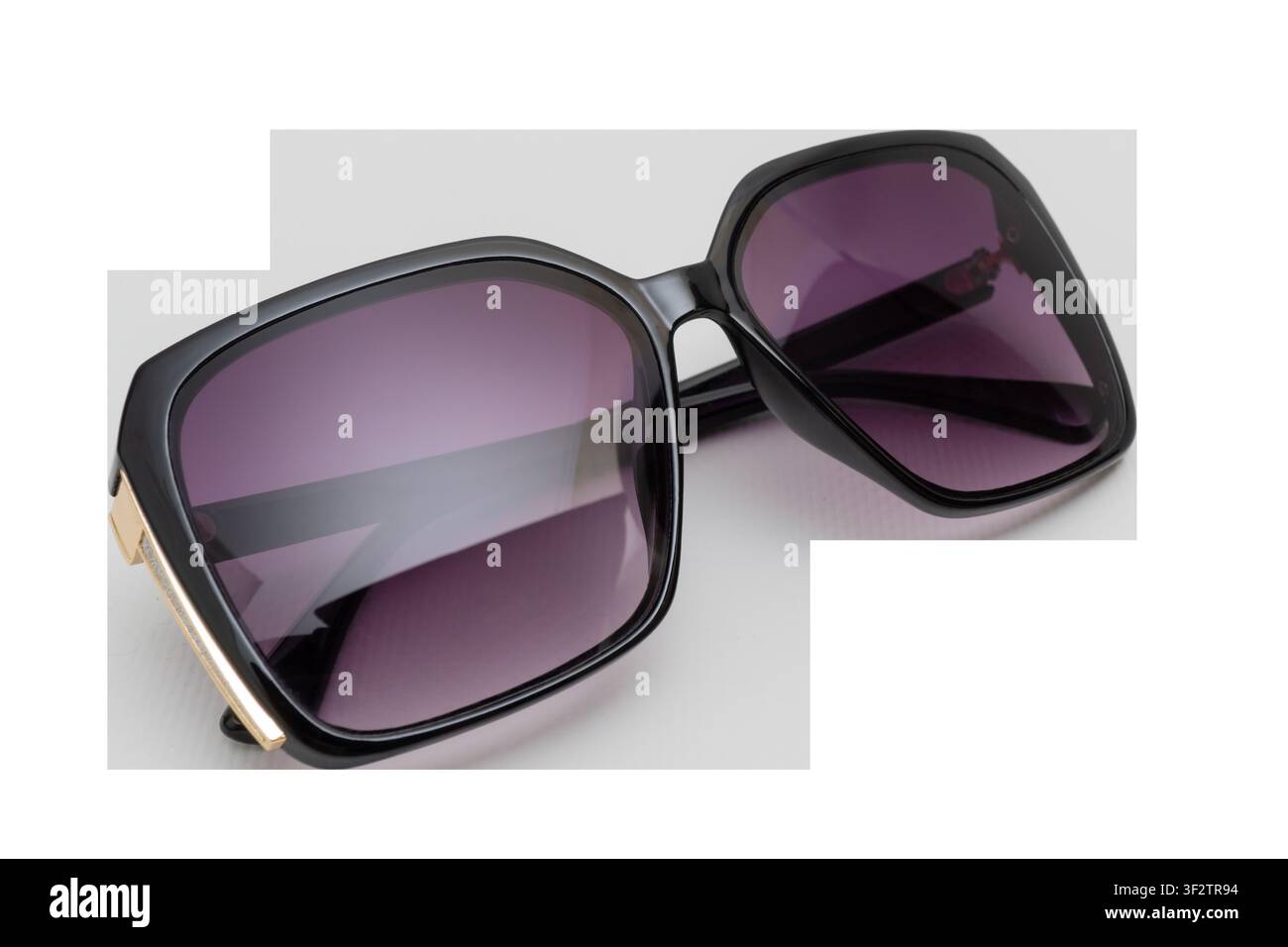 Eleganti occhiali da sole quadrati oversize neri con lenti viola e dettagli dorati Foto Stock