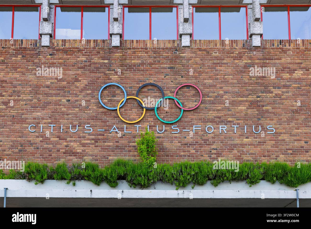 Amsterdam, Paesi Bassi, 23 maggio 2026. La facciata storica in mattoni dell'Olympisch Stadion con gli anelli olimpici colorati e il classico mo latino Foto Stock