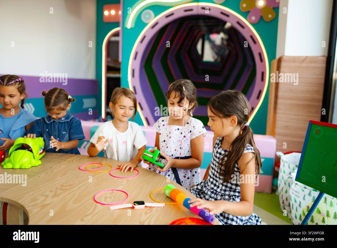 Ragazze che giocano con i giocattoli nella stanza dei giochi per bambini Foto Stock
