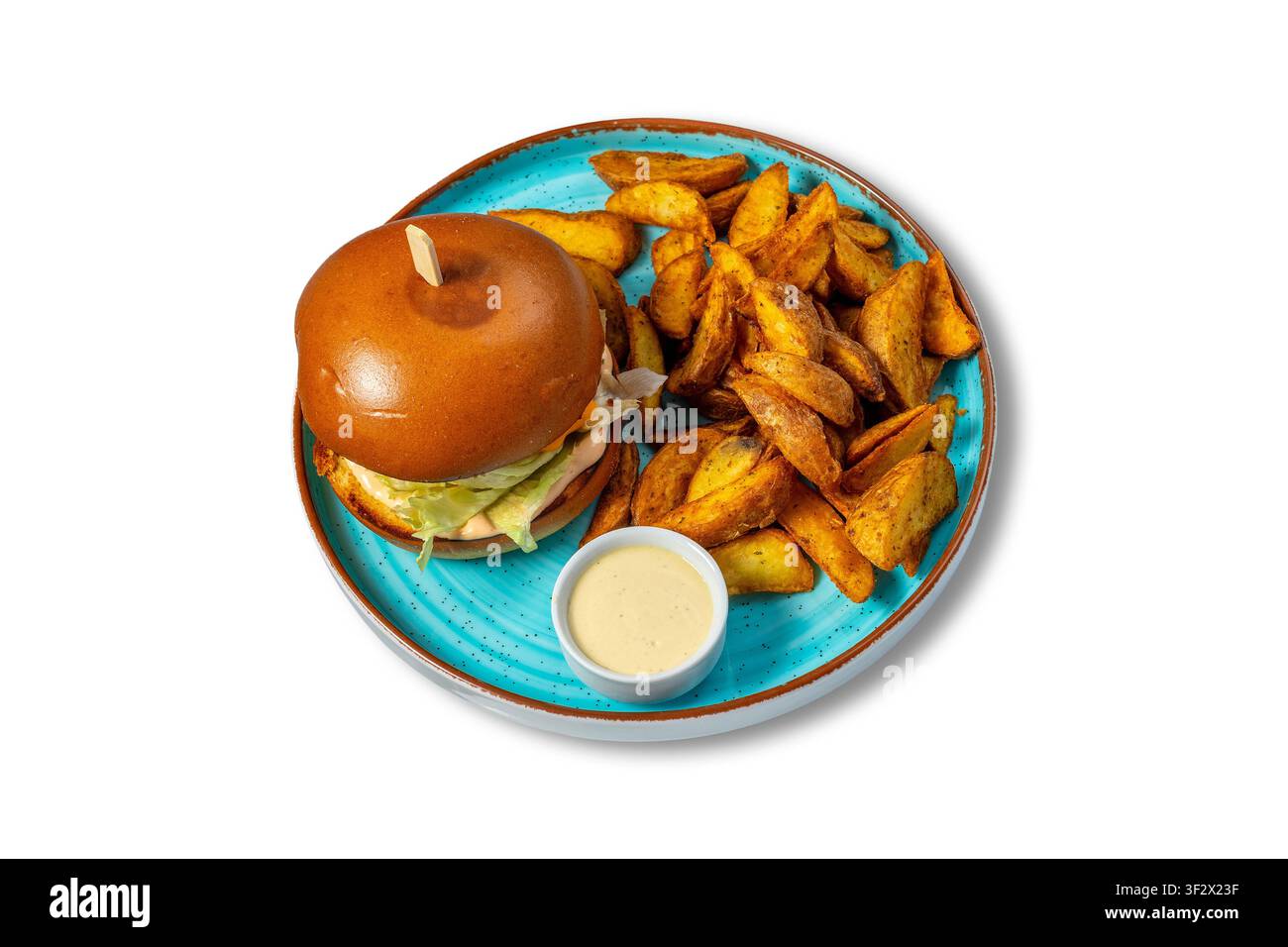 Hamburger di pollo con patatine a cubetti e salsa cremosa su piatto blu Foto Stock