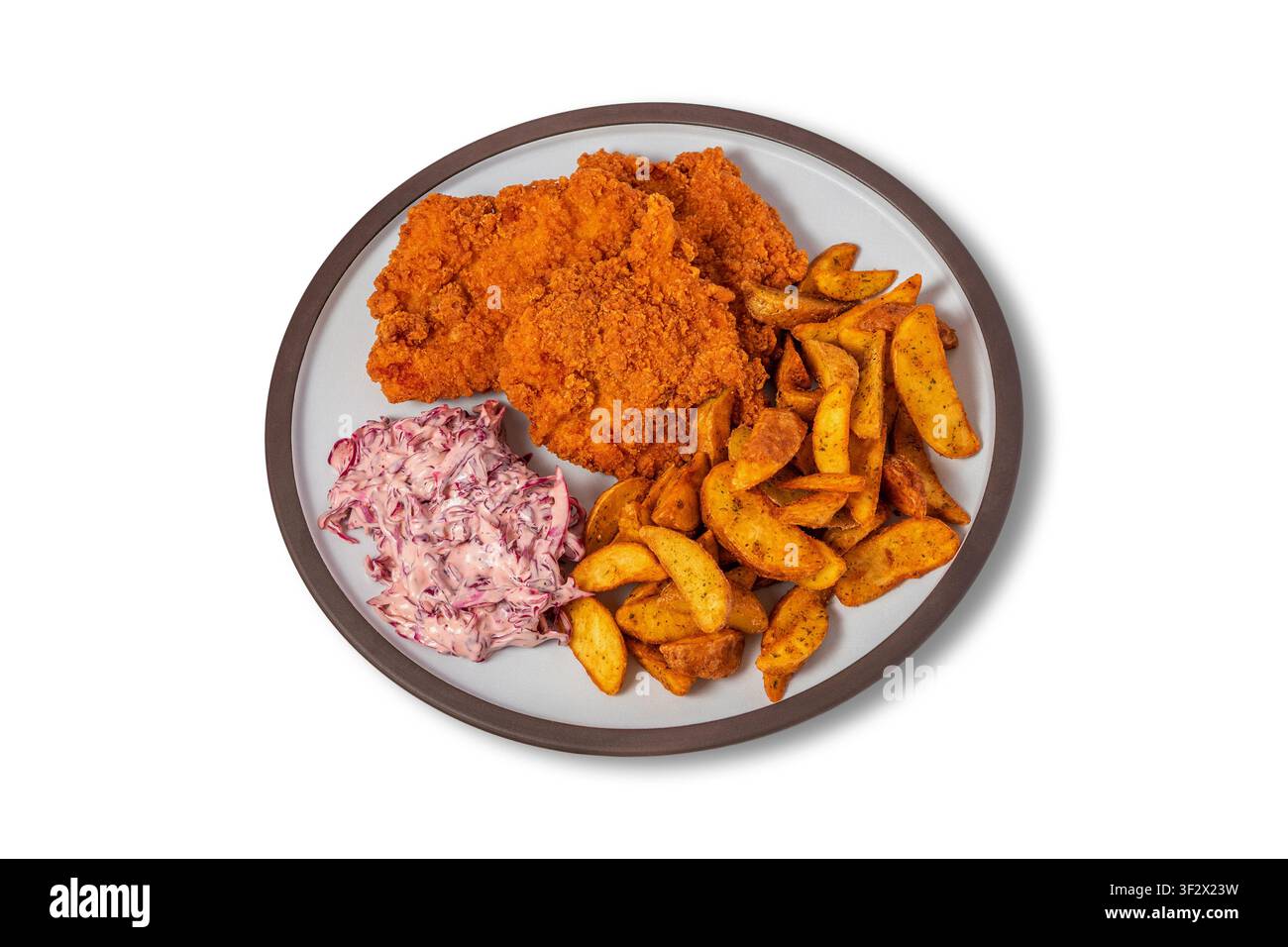 Schnitzel di pollo croccante con patatine Wedges e insalata di cavolo rosso su piatto Foto Stock