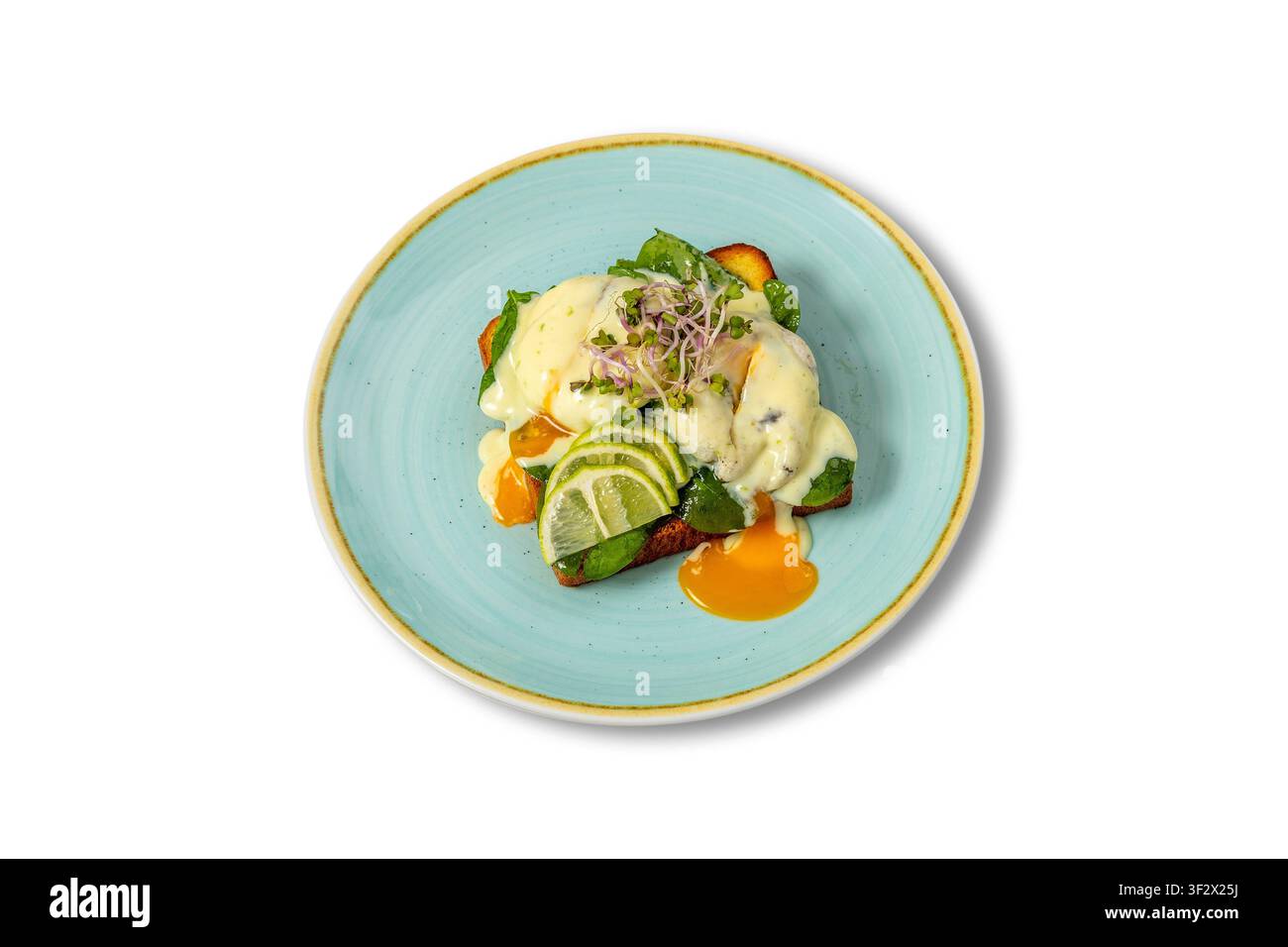 Uova Benedict con salsa olandese, spinaci e lime su pane tostato Foto Stock