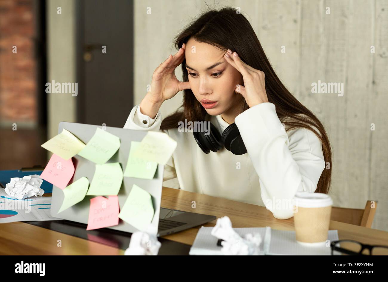 Difficoltà di lavoro. Donna che tiene la testa davanti al notebook Foto Stock