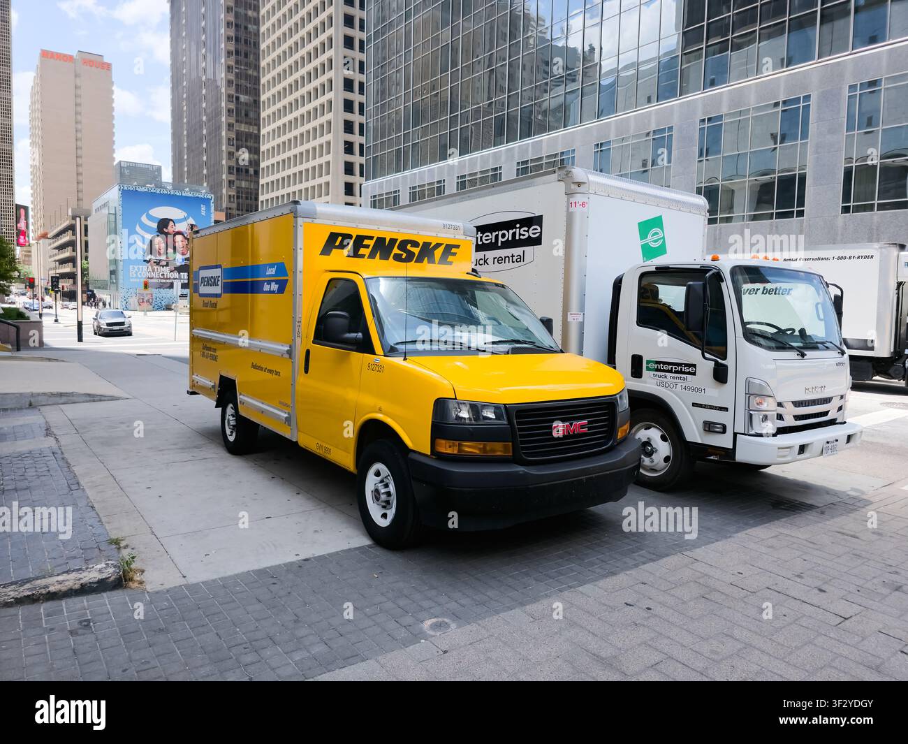 DALLAS, TX, USA - 11 LUGLIO 2026: Un camion a noleggio Penske è parcheggiato accanto a un camion a noleggio Enterprise su una strada trafficata del centro di Dallas, circondato da Foto Stock