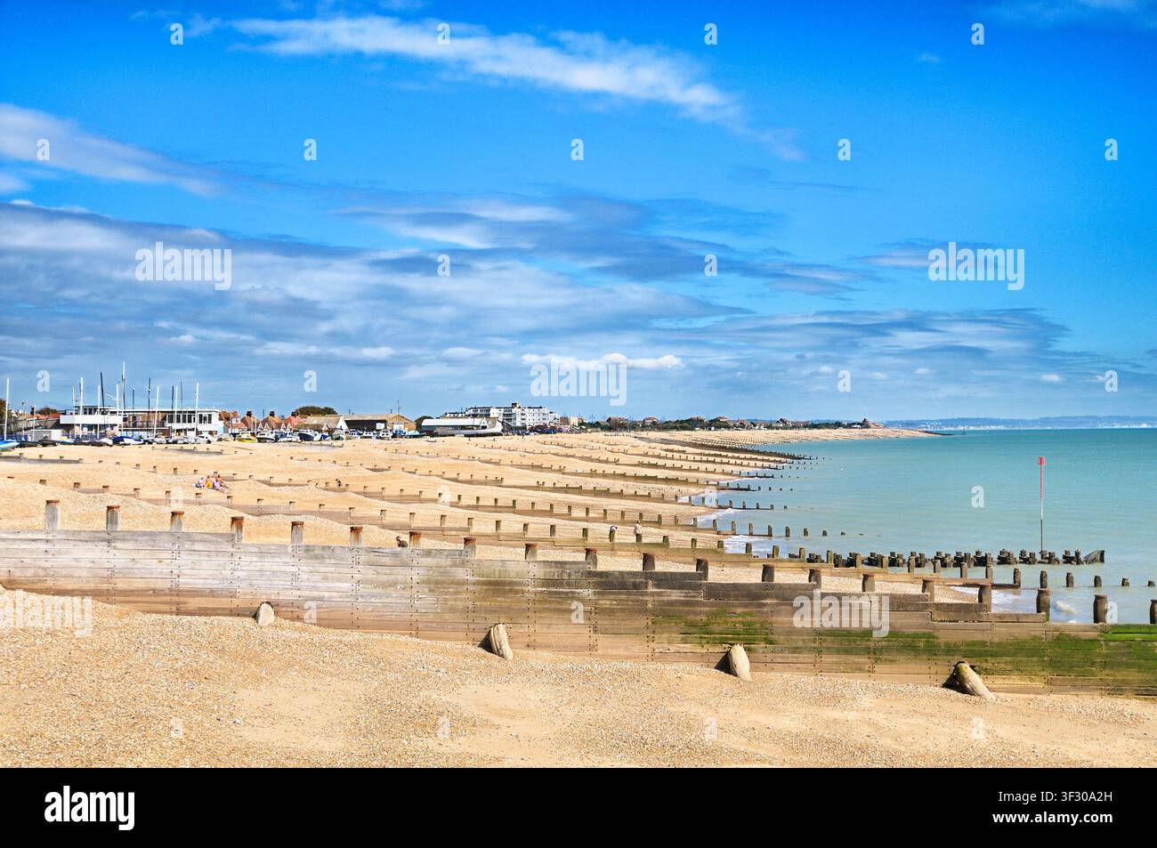 Vista di una giornata soleggiata sui groyne in ghiaia e legno del lungomare di Eastbourne, East Sussex, Inghilterra, Regno Unito. spiagge costa litorale costa Foto Stock