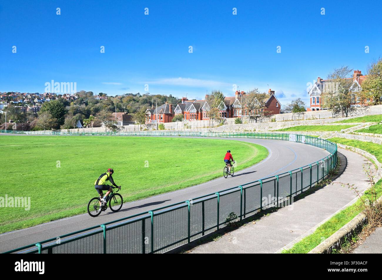 Ciclisti che pedalano intorno al Preston Park Velodrome, la più antica pista ciclabile del Regno Unito aperta nel 1887. Brighton e Hove East Sussex Inghilterra UK Ciclismo Foto Stock