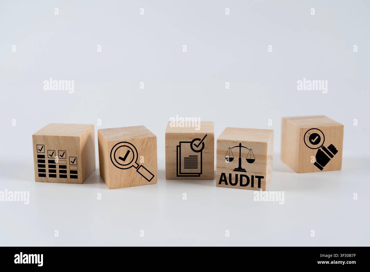 Cubi di legno stampati con icone di audit, checklist, verifica e conformità su uno sfondo bianco, che illustrano la revisione aziendale, il controllo interno, Foto Stock