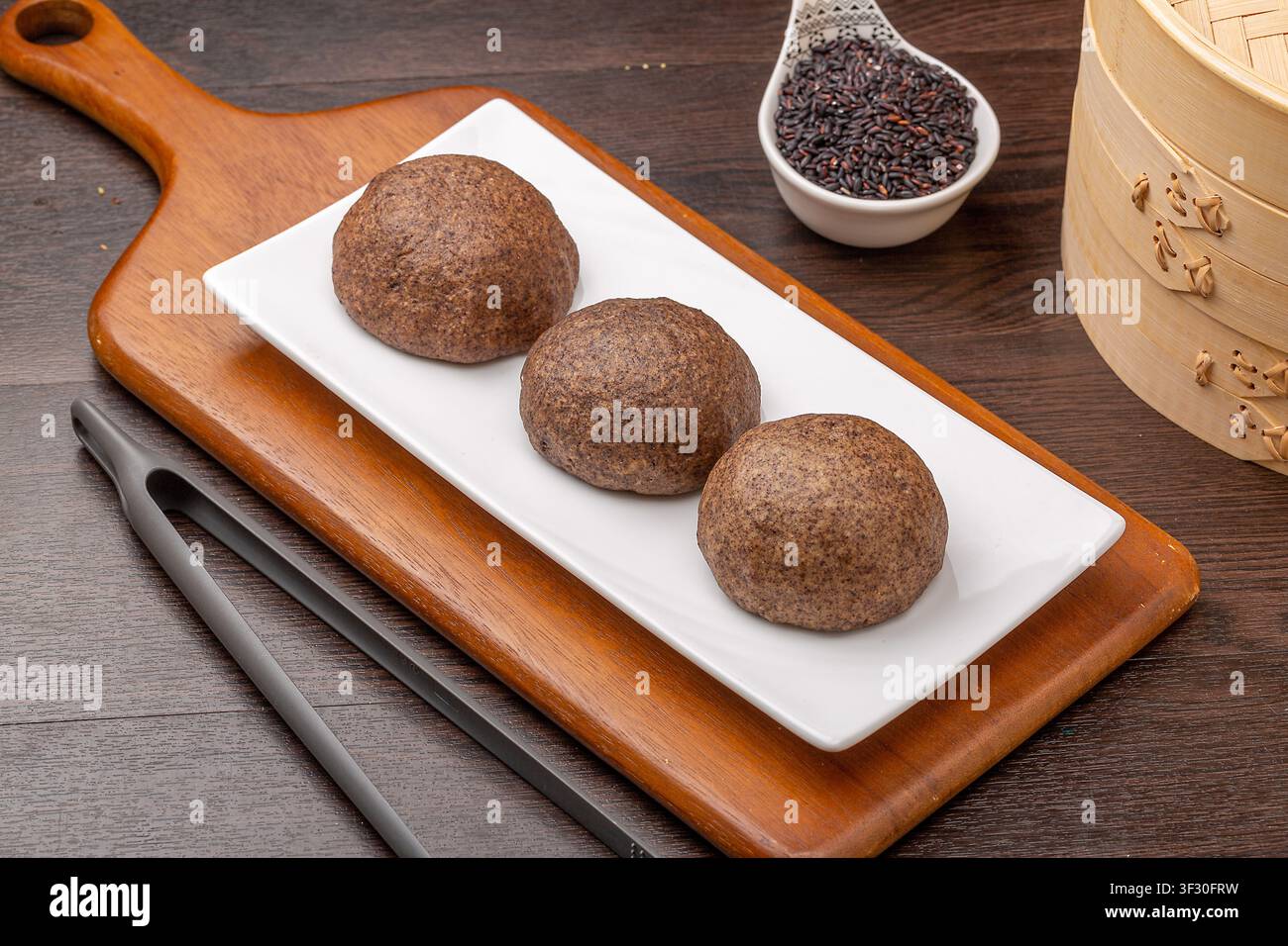 Brioche di riso nero sano wowotou servite come colazione asiatica nutriente a più cereali. Foto Stock