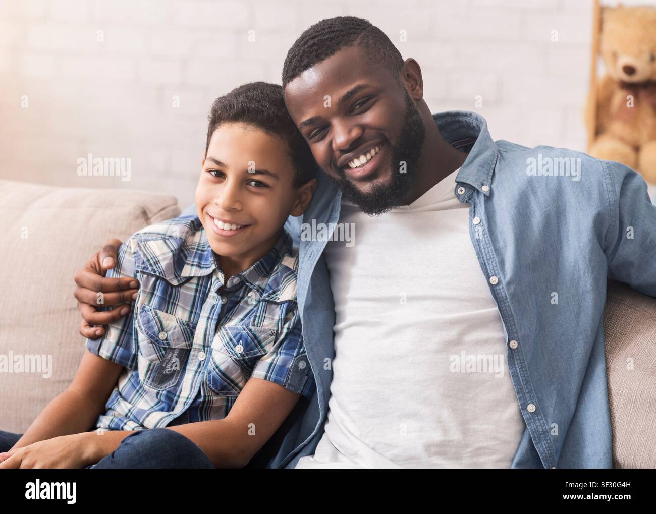 Felice padre e figlio afroamericani che prendono selfie a casa Foto Stock