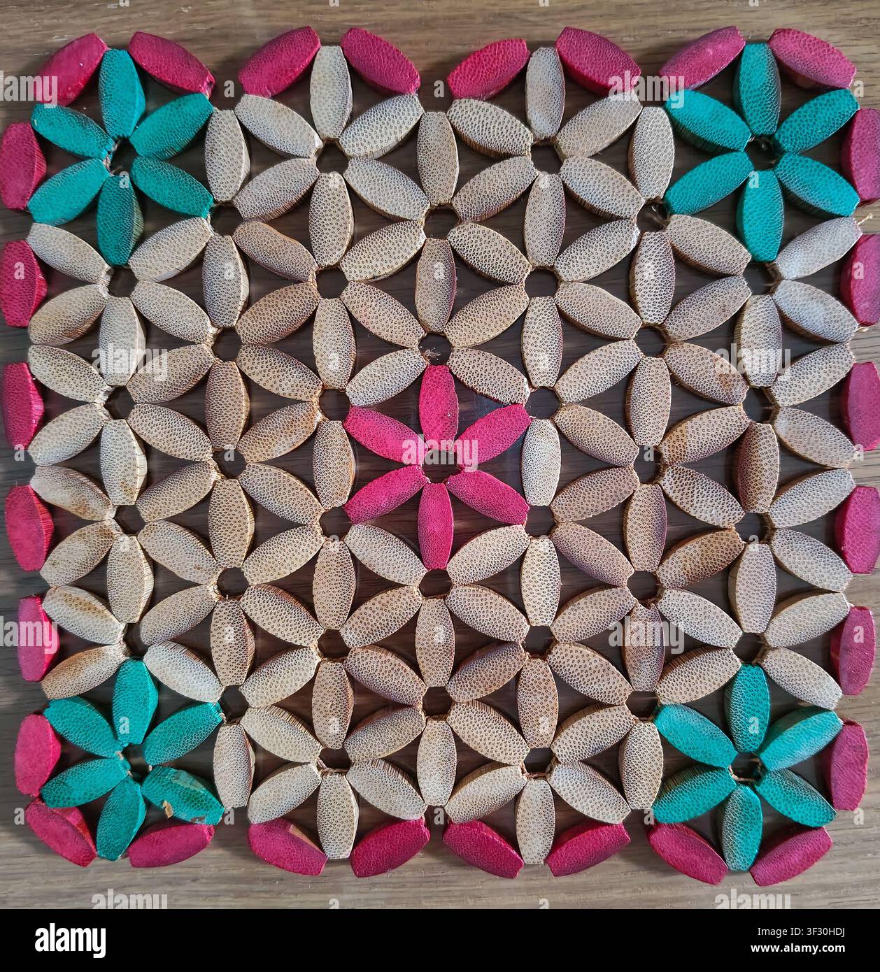 Sottobicchiere in legno resistente al calore con motivi di perline a fiori colorati, perfetto per proteggere i tavoli da pranzo da pentole, piatti e tazze calde. Foto Stock