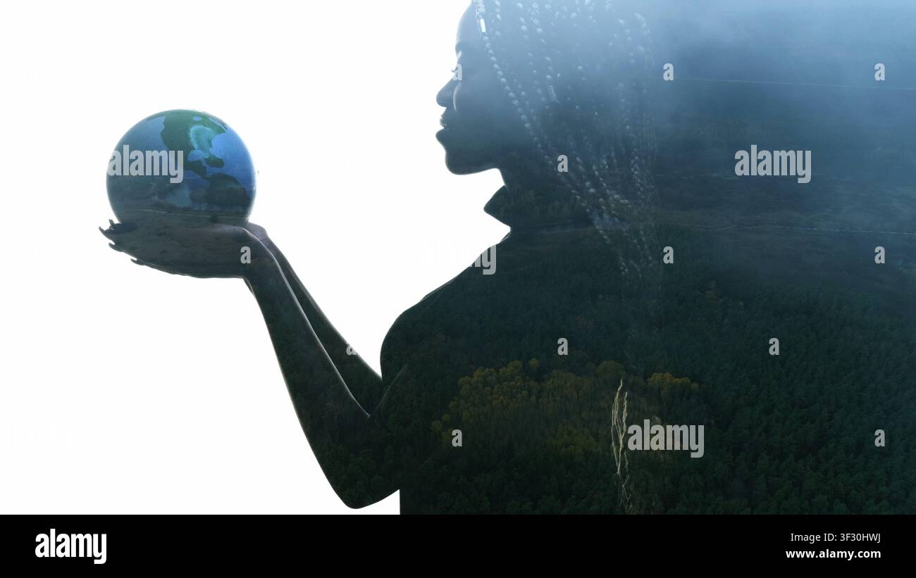 Donna in silhouette di una Terra sostenibile nel globo tra le mani Foto Stock