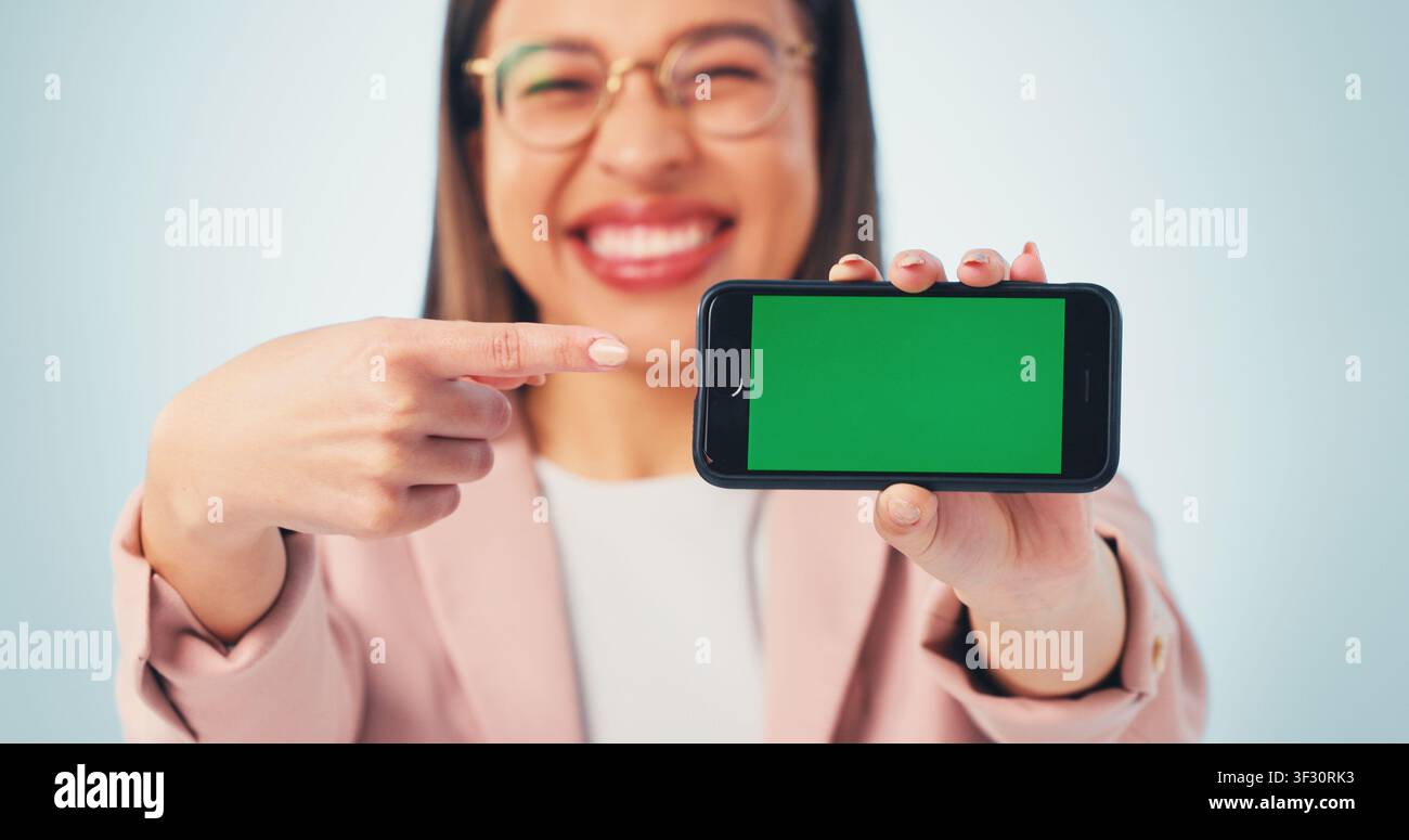 Indicazione, schermo verde o mani di una donna d'affari con telefono per la pubblicità di un'app finanziaria. Felice, presentazione o consulente finanziaria con cellulare Foto Stock