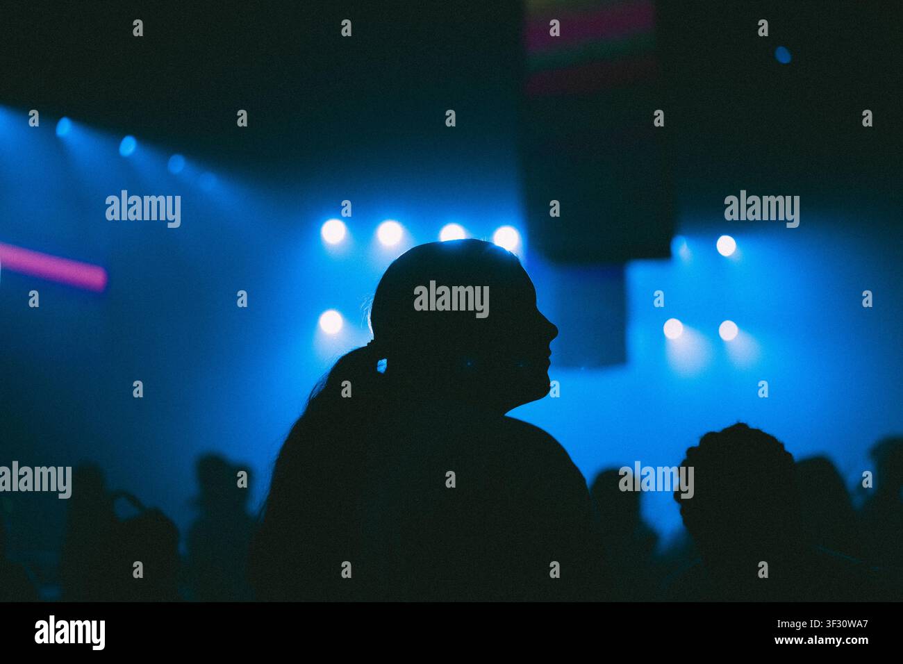 Silhouette di una persona che balla durante un concerto in un nightclub Foto Stock