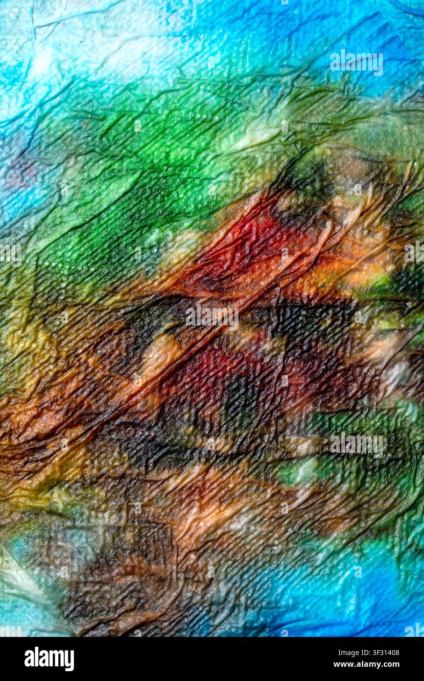 Un macro vivace di una superficie accartocciata e multicolore con sfumature di verde, blu e marrone. Le texture profonde e le pieghe intricate creano una u Foto Stock