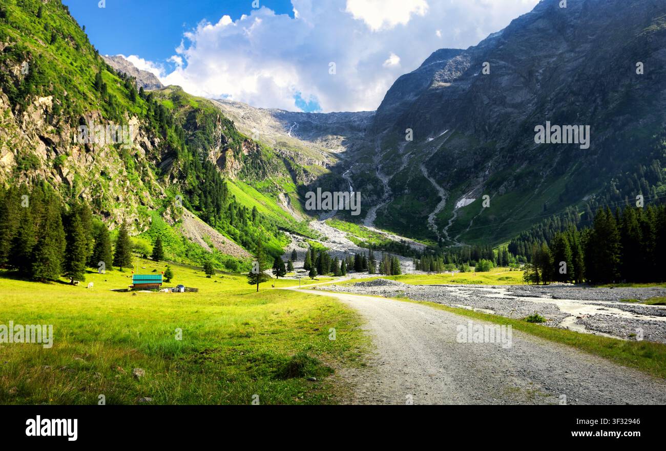 Alpi austriache con cime innevate, valli rigogliose e un piccolo villaggio di montagna sotto un cielo blu terso - Lusenstal vicino a Innsbruck Foto Stock