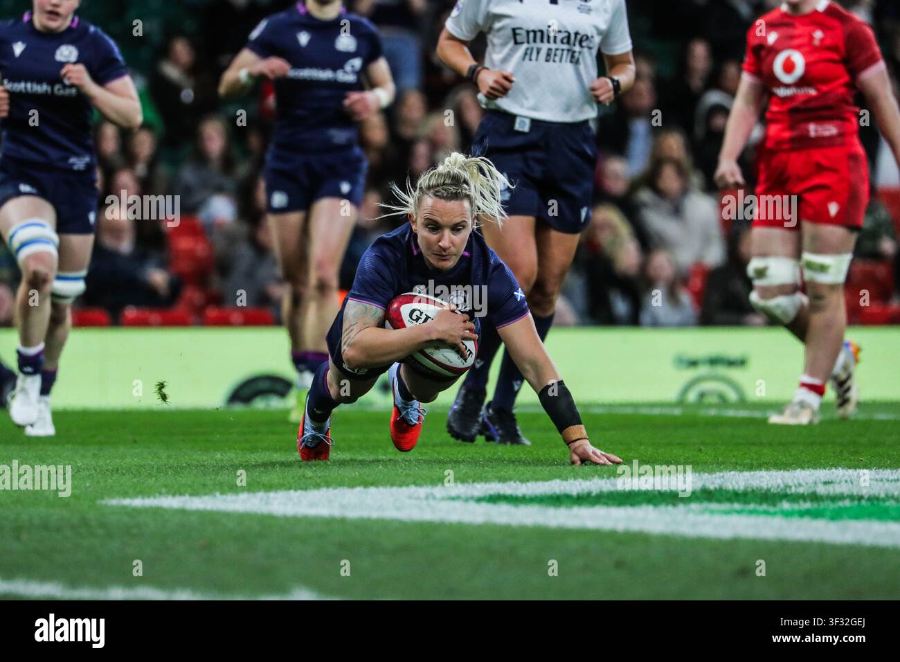 Chloe Rollie, full-back della Scozia, segna un tentativo contro il Galles durante la partita del Guinness Women’s Six Nations al Principality Stadium, Cardiff, Galles. Foto Stock