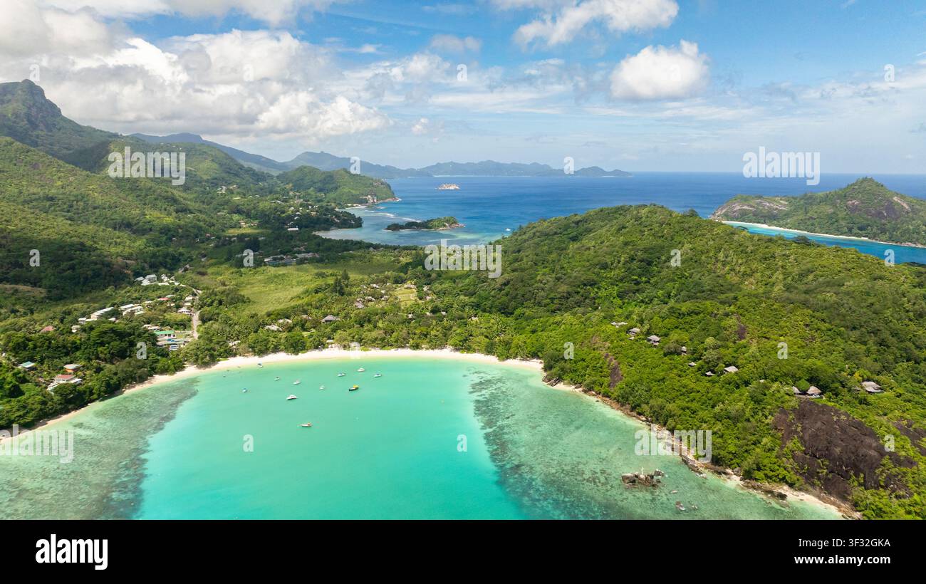 Vista aerea della baia con acque azzurre calme e scenario montano drammatico. Spiaggia di Port Launay. Seychelles. Foto Stock