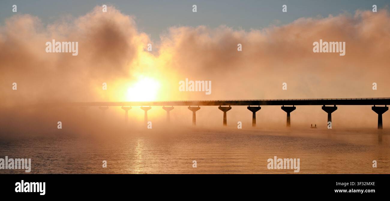 Due pescatori sotto il ponte della Natchez Trace Parkway all'alba sul fiume Tennessee nel nord-ovest dell'Alabama, USA. Foto Stock
