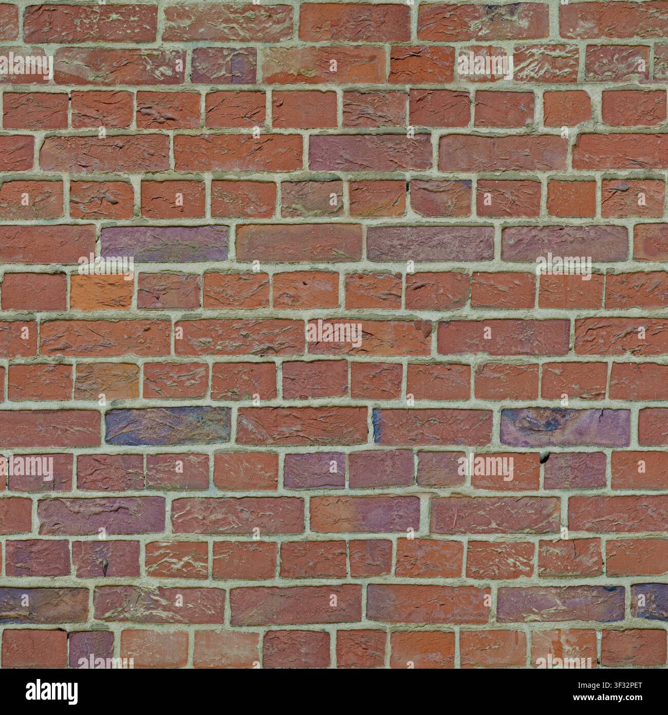 Un muro composto da mattoni di argilla strutturati multicolori in sfumature di rosso e viola. Foto Stock