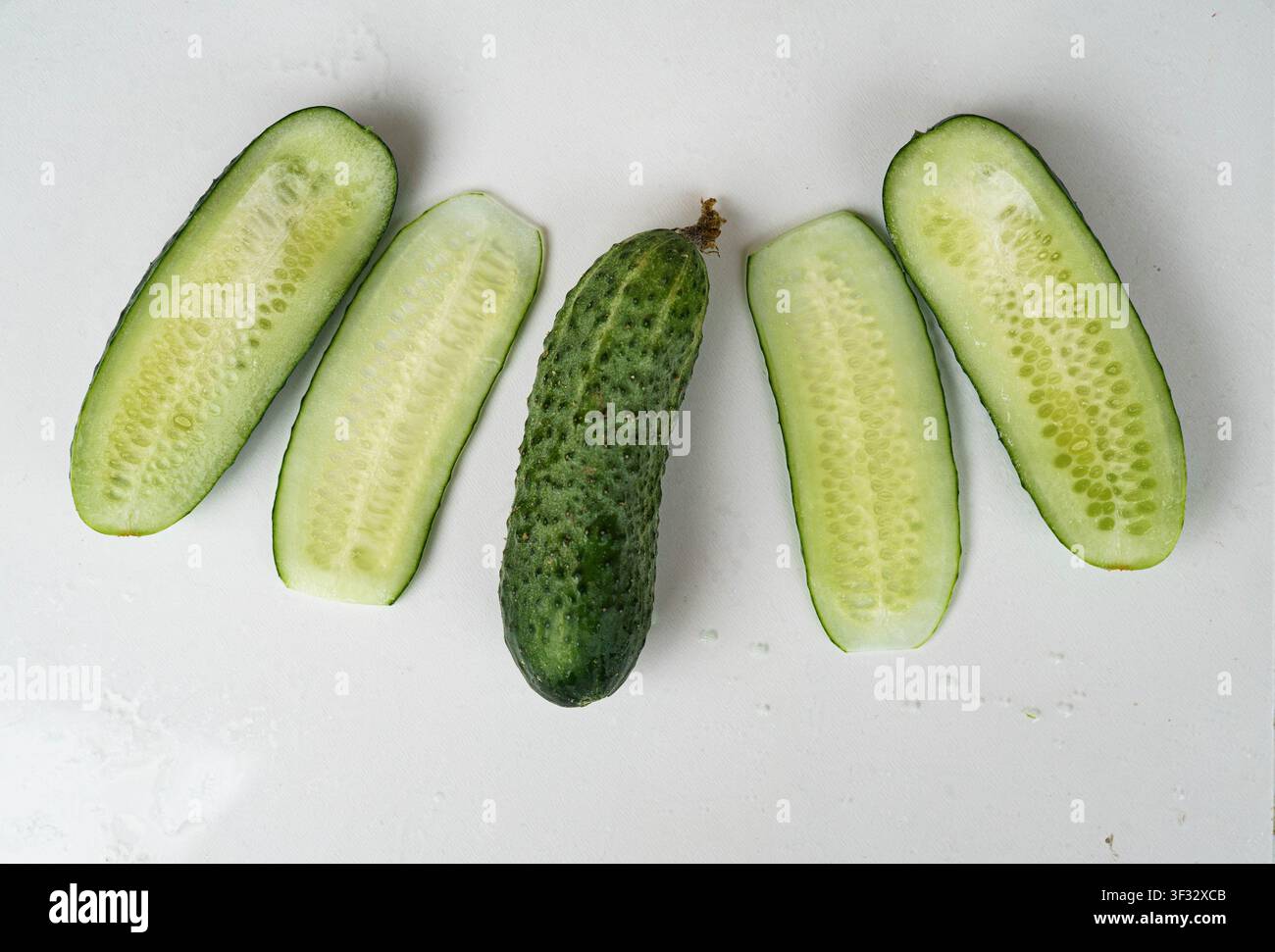 Cetriolo fresco intero e affettato isolato su sfondo bianco Foto Stock
