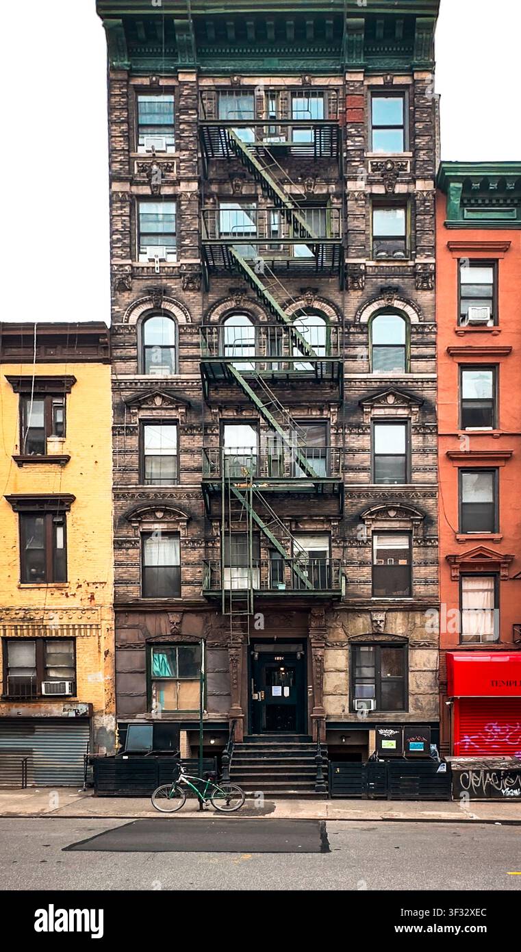 New York City, USA, 30 aprile 2024, un edificio in mattoni con una scala antincendio esterna in metallo situata su Madison Street Foto Stock