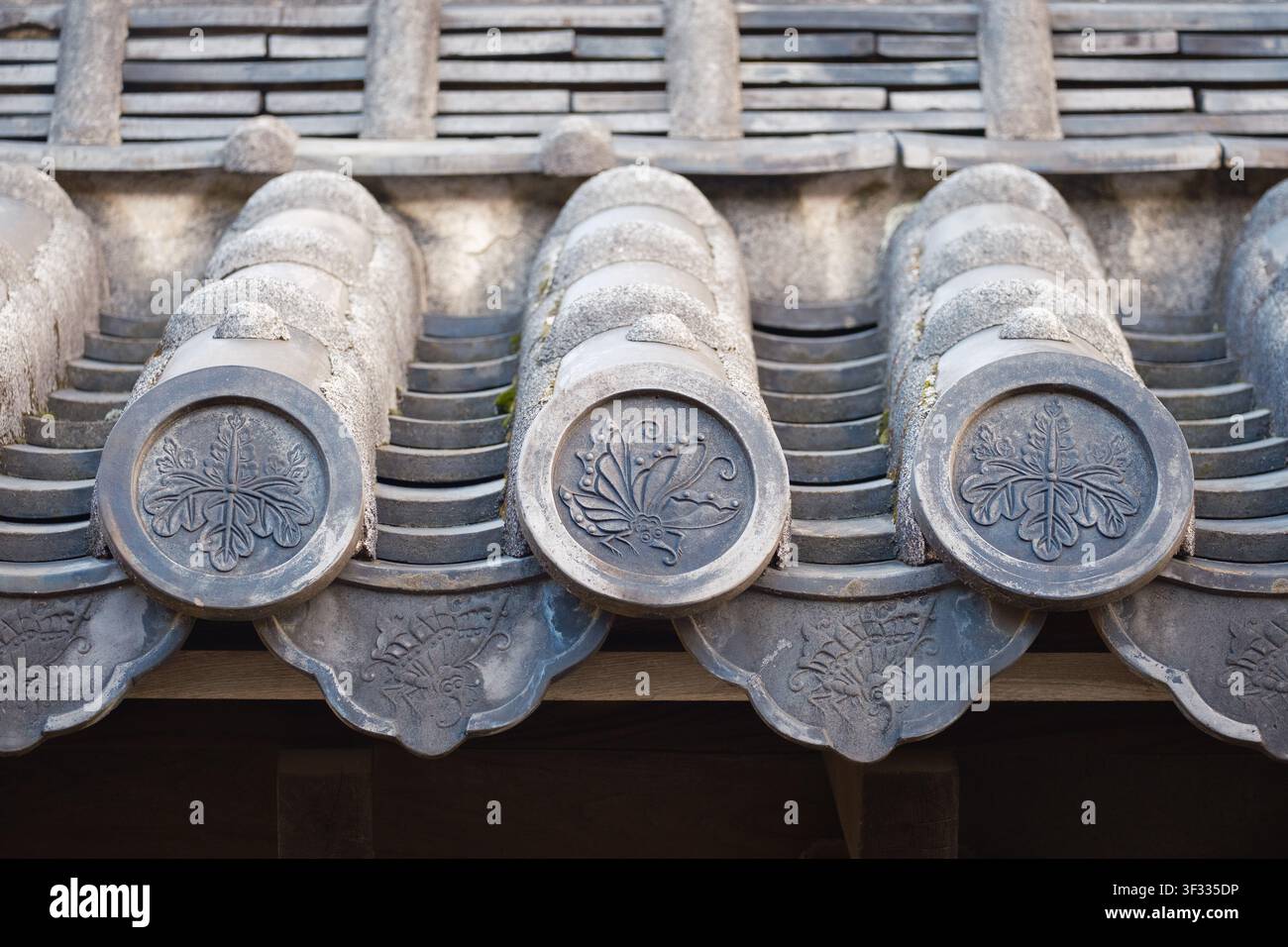 Una fila di tegole decorative chiamate gatou orna il tetto del castello di Himeji a Himeji, in Giappone. Foto Stock
