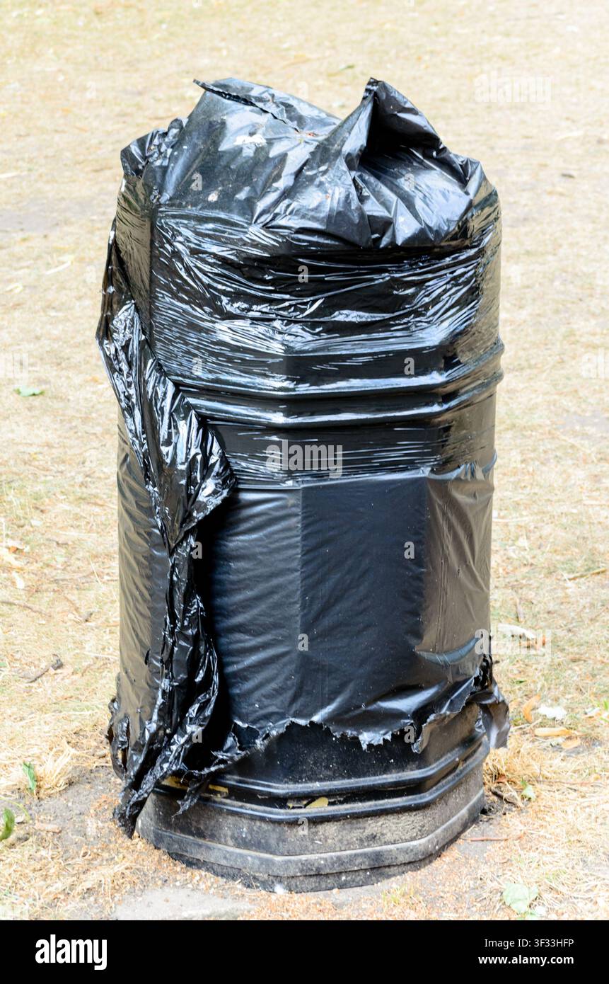 Cestino della spazzatura/cestino coperti da plastica nera, non in uso, Regno Unito Foto Stock