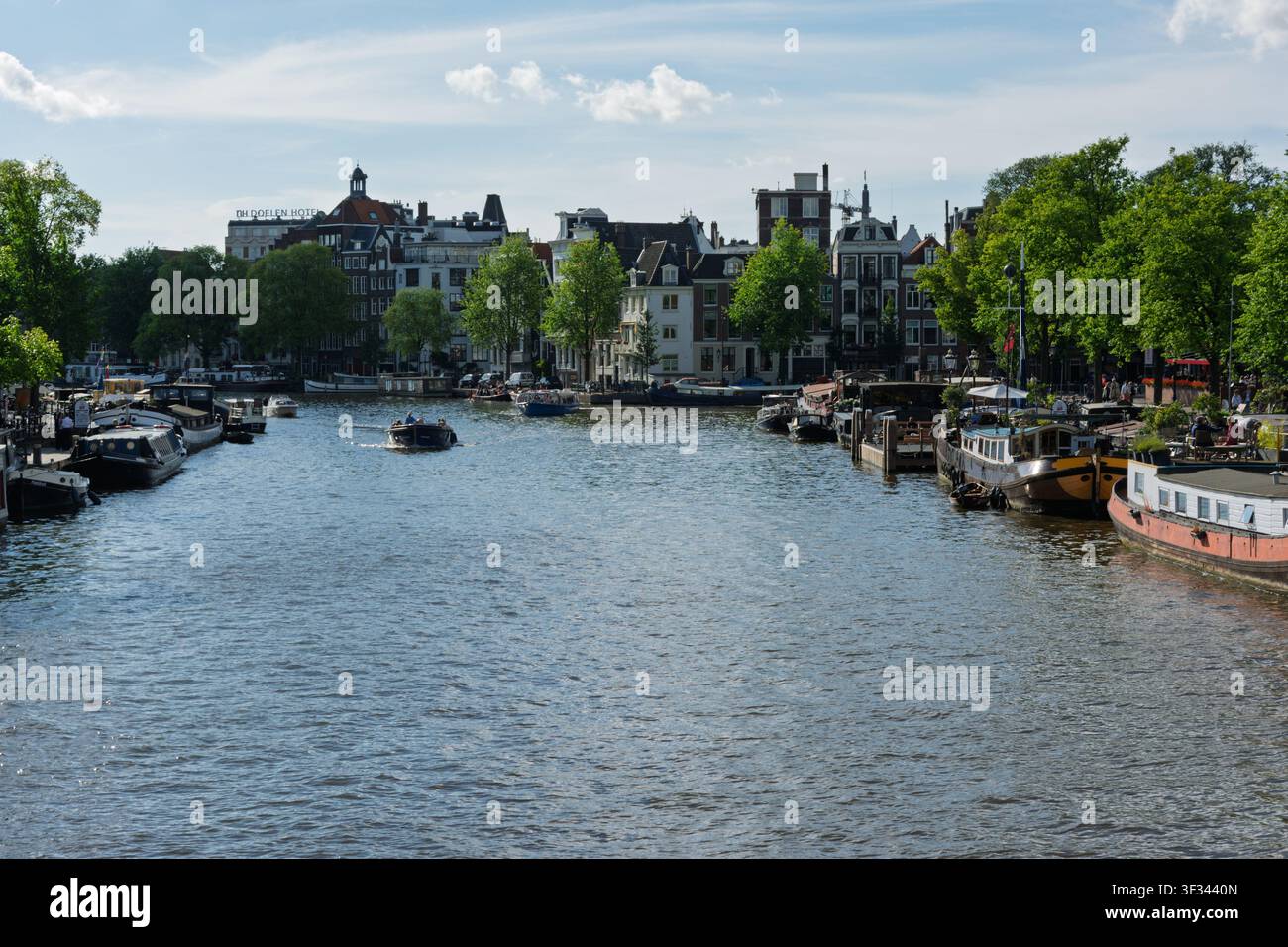 Amsterdam, Paesi Bassi. 22 giugno 2014, canale di Amsterdam sul fiume Amstel con case galleggianti e edifici cittadini in fiore Foto Stock
