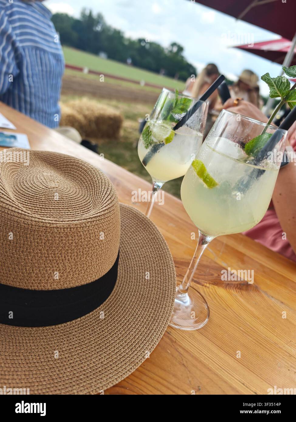Cocktail con lime e menta a un torneo di polo vicino a Francoforte sul Meno, Germania, con il campo da polo sullo sfondo. - Immagine stock catturata con smartphone