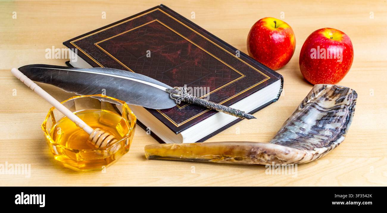 Simboli ebraici per il nuovo anno tra cui shofar, miele, mele, libro e penna d'oca su superficie di legno Foto Stock