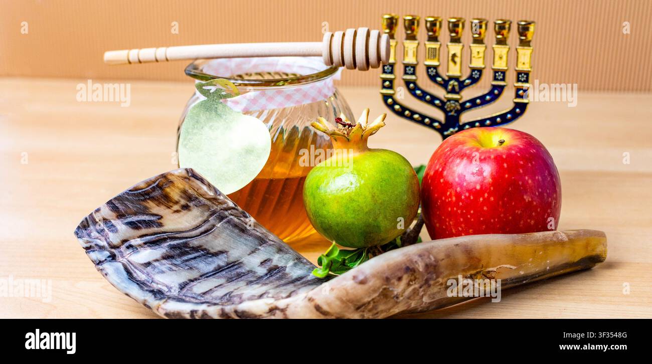 Simboli di Rosh Hashanah tra cui shofar, vasetto di miele, mele e melograno Foto Stock