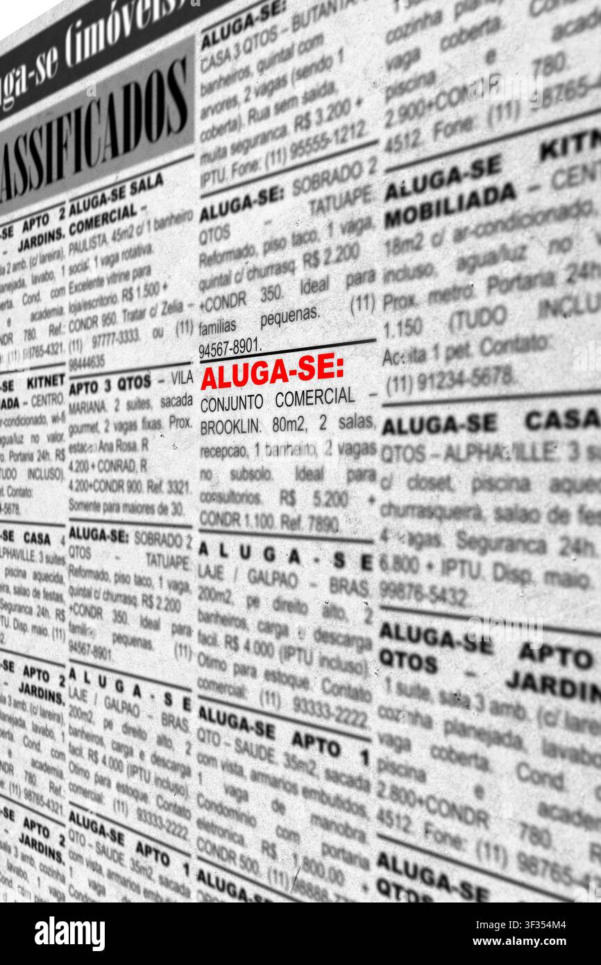 Primo piano di annunci falsi con informazioni generiche – annunci di giornale stampati che offrono proprietà in affitto. Testo in portoghese brasiliano. Foto Stock