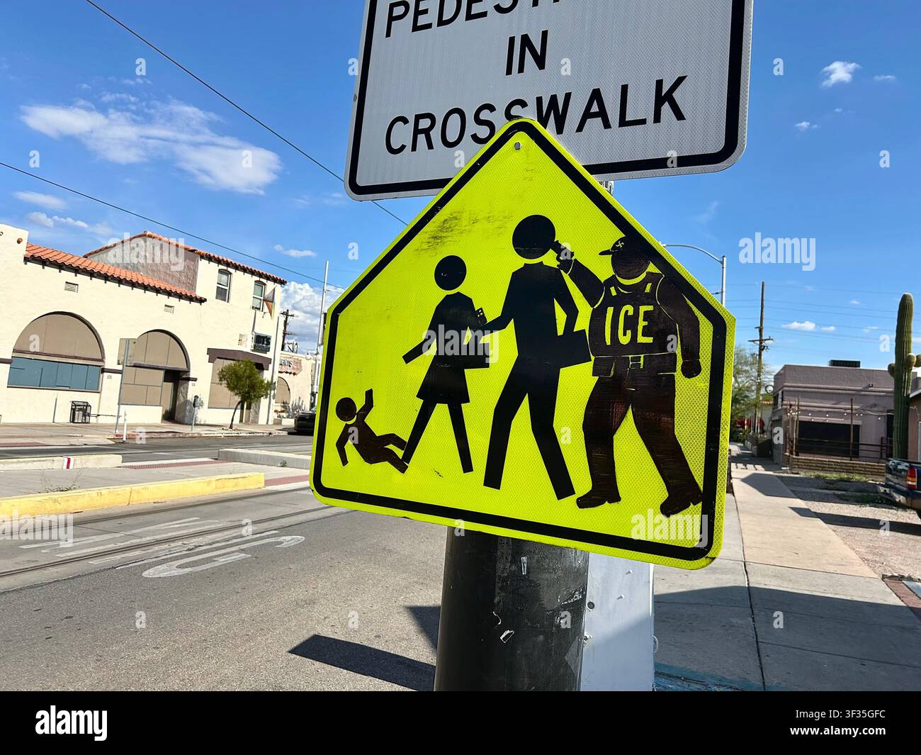 Un cartello che indica un passaggio pedonale su North 4th Avenue è stato modificato per raffigurare un agente dell'ICE che punta una pistola su delle persone, Tucson, Arizona, USA Foto Stock