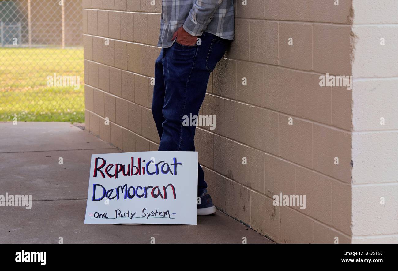 Manifestante tiene un cartello fatto a mano con la scritta "Republicrat Democran One Party System" che protesta contro l'influenza delle aziende sul duopolio politico delle elezioni e la scelta Foto Stock
