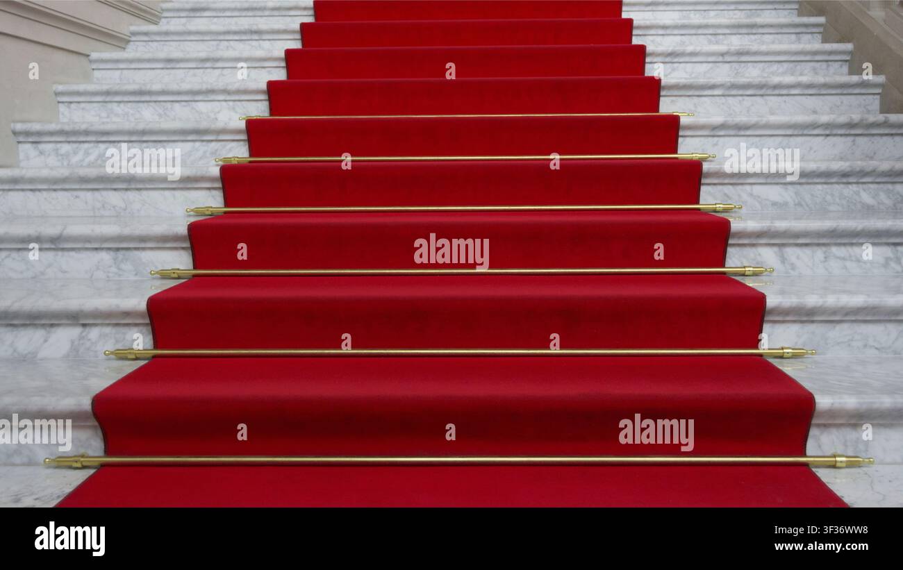 Scalinata elegante con un tappeto rosso lussuoso e gradini in marmo bianco Foto Stock