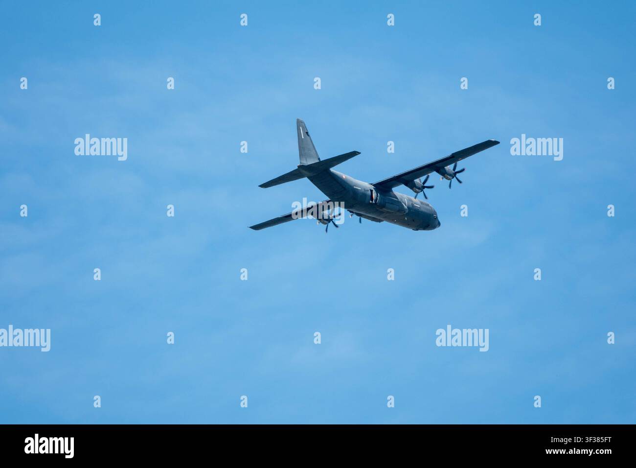 Aereo da trasporto militare cargo che vola su un cielo blu terso durante il volo diurno Foto Stock