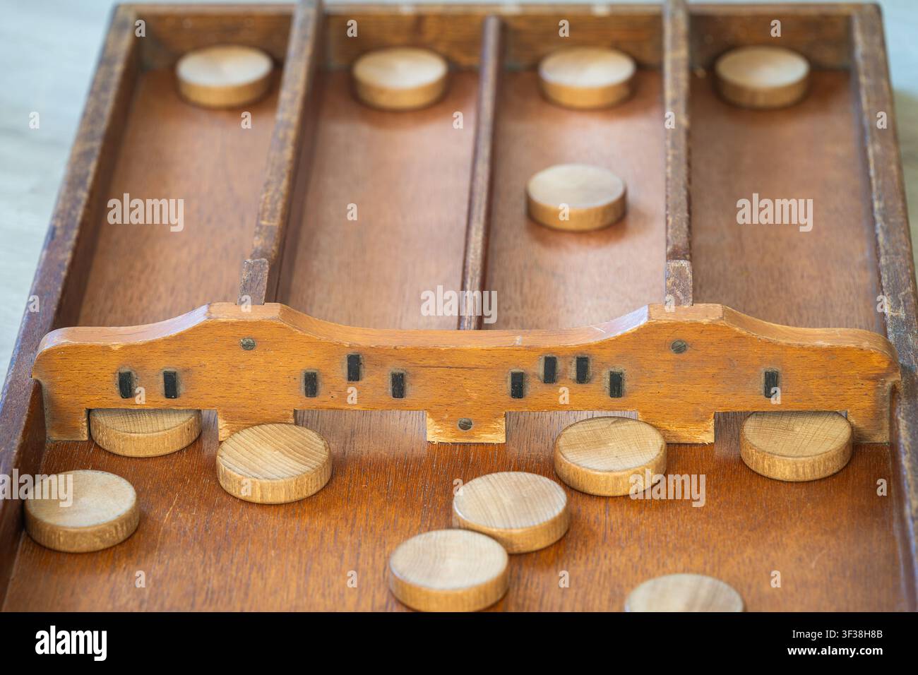 Gameplay di sjoelen, classico gioco da tavolo olandese con dischi di legno e tavola chiamata sjoelbak Foto Stock
