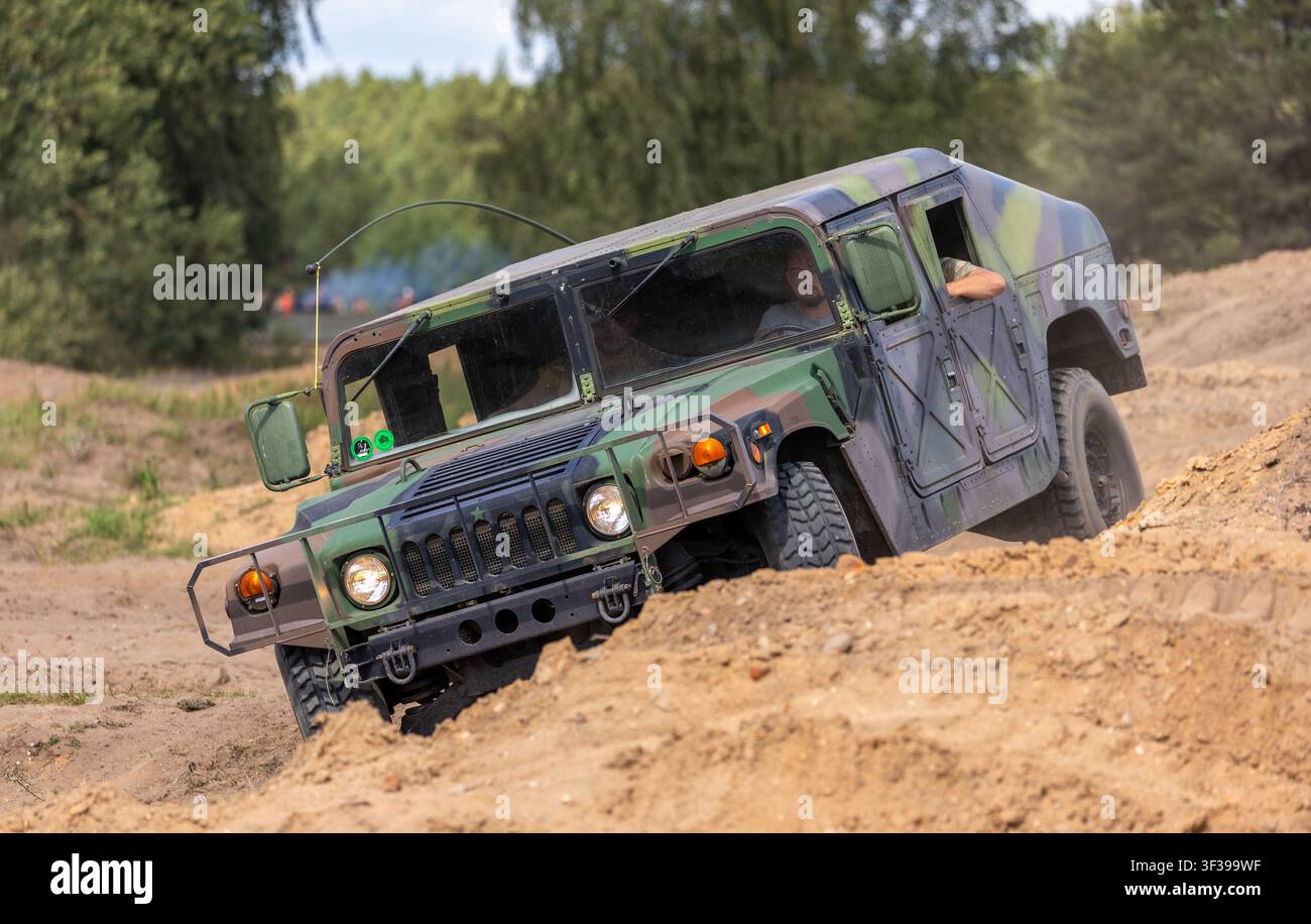 Borne Sulinowo, Polonia – 13 agosto 2023: Veicolo Humvee mimetizzato che si muove su terreno sabbioso impegnativo all'aperto Foto Stock