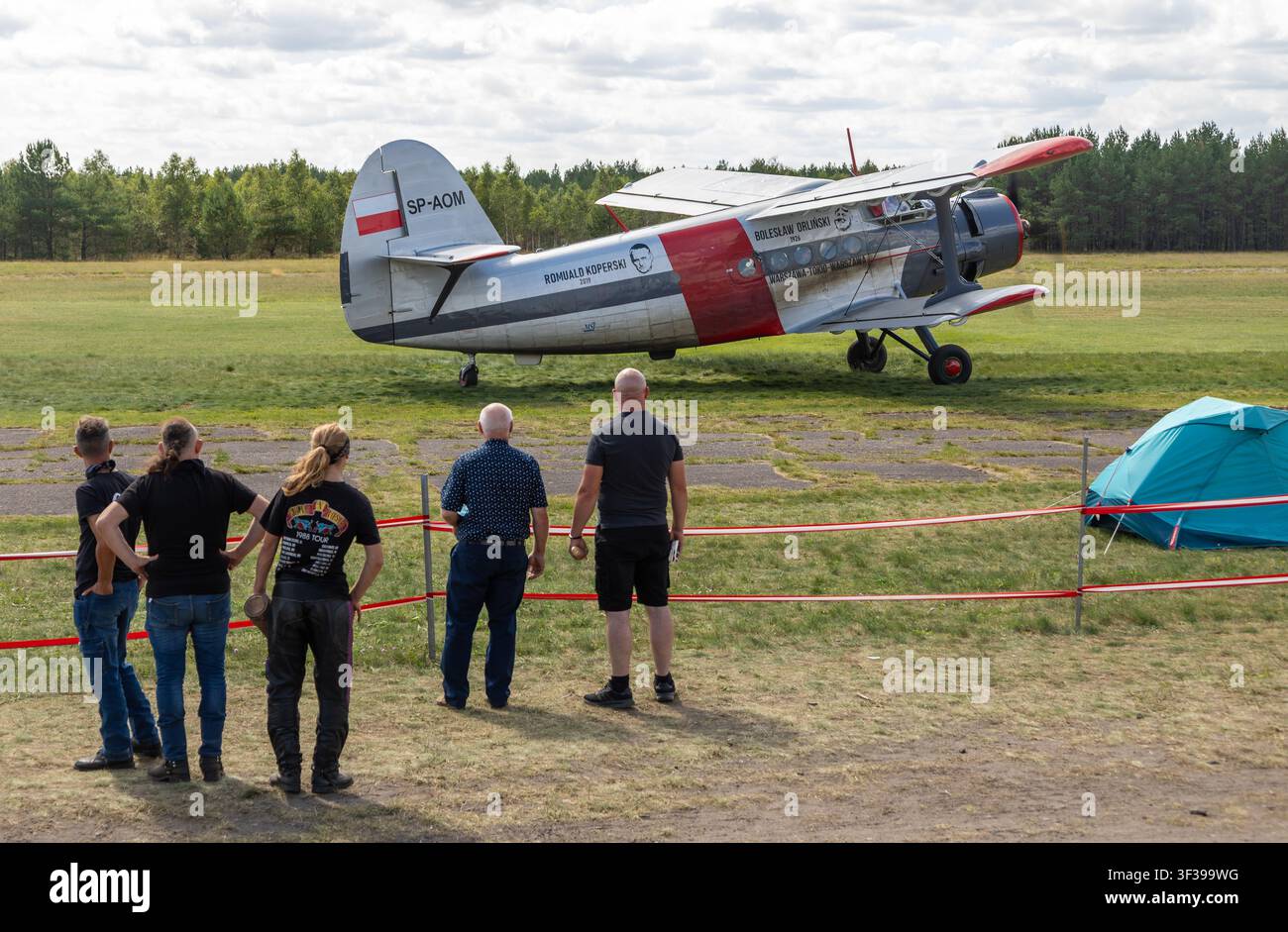Borne Sulinowo, Polonia – 13 agosto 2023: Spettatori che osservano un biplano Antonov An 2 durante un evento aereo all’aperto Foto Stock