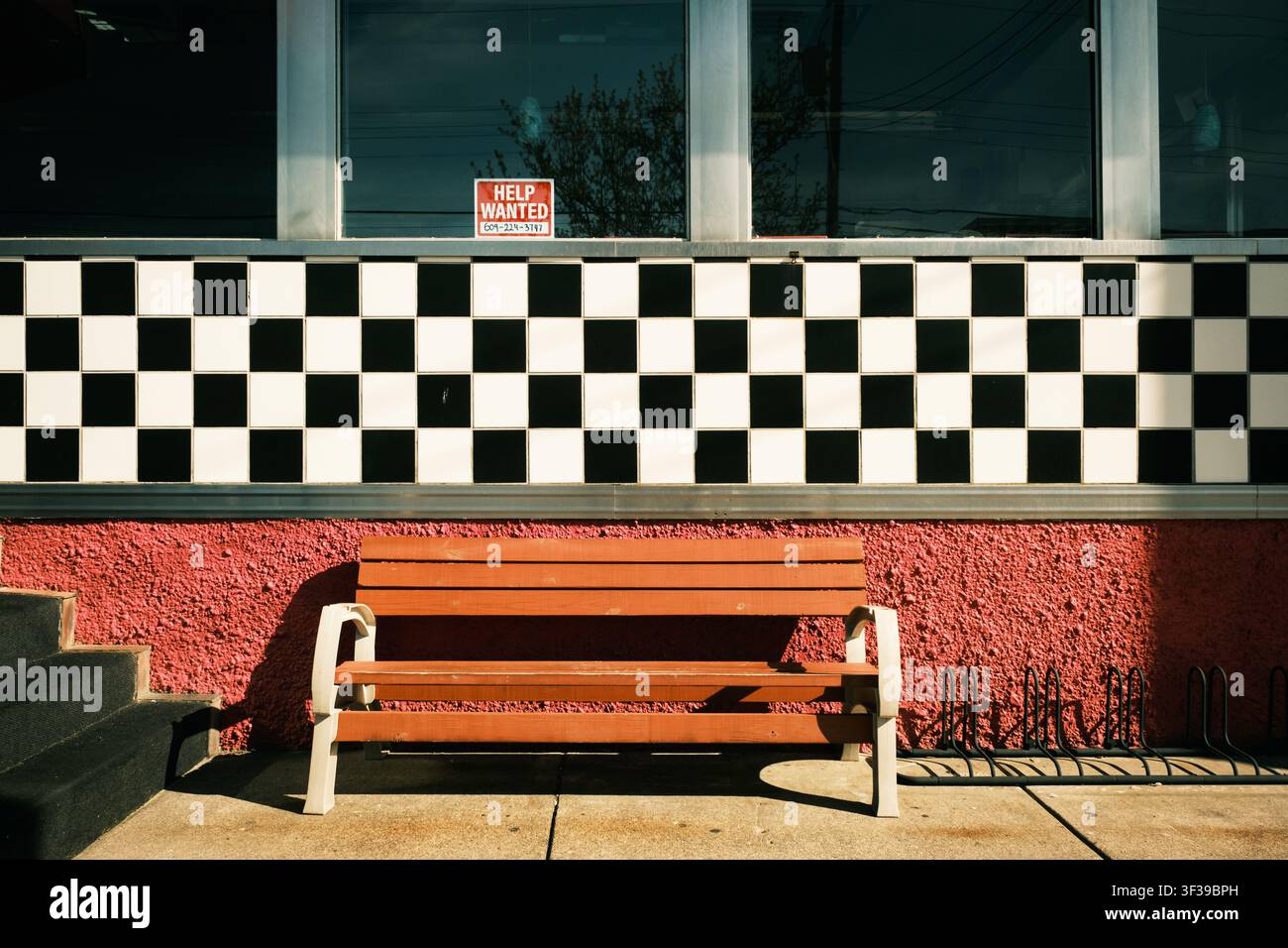 Una panchina rossa davanti a un muro a scacchi bianchi e neri al Pink Cadillac Diner, Wildwood, New Jersey Foto Stock